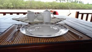a plate on a table with utensils on top of a table at Salt Lake Cabanas & Restaurant in Tangalle