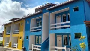 un edificio con vernice blu e gialla sopra di Lagoa Encantada I a Ilhéus