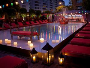 a pool with candles and red chairs and lights at Faena Hotel Buenos Aires in Buenos Aires