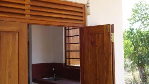 an open door to a bathroom with a window at Salt Lake Cabanas & Restaurant in Tangalle