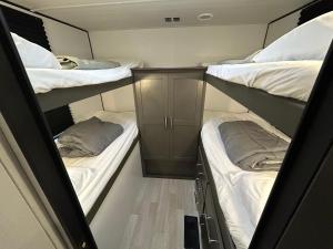 a small room with two bunk beds and a cabinet at The Bunkhouse Camper in Klamath