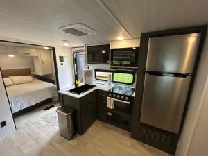 a kitchen with a refrigerator and a bed in a rv at The Bunkhouse Camper in Klamath