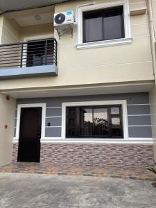a house with a window and a door and a balcony at Three Bedrooms Two Storey Home with Parking in Santa Rosa