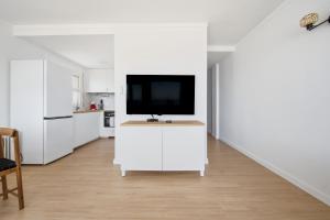 a white kitchen with a tv on a white counter at Vista Roses Mar - Ariadna in Roses