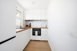 a kitchen with white cabinets and a wooden floor at Vista Roses Mar - Ariadna in Roses +12 photos