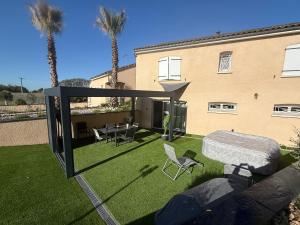 a garden with a table and chairs and a building at Serenity's Home in Naintré