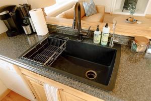 a kitchen sink with a dish drying rack over it at Paradise Creek Cottage in Moscow +57 photos