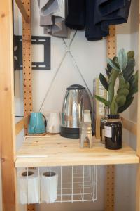 a shelf with a tea kettle and a plant on it at Uncle NID Hostel in Lat Krabang +88 photos