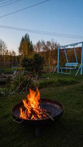 a fire pit in the grass with a bench in the background at Dom na Przedgórzu-Spokojny pobyt blisko górskich tras in Świeradów-Zdrój +22 photos