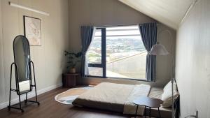 a bedroom with a bed and a large window at Nhà bạn Nhí in Khu Chi Lăng