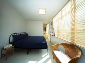 a bedroom with a blue bed and a window at Uncle NID Hostel in Lat Krabang