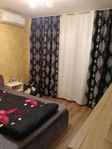a room with a bed and a window with a curtain at casa lidia in Brăila