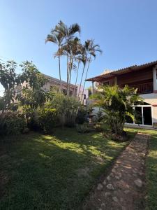 a yard with palm trees and a house at Cozy beach house getaway in La Libertad