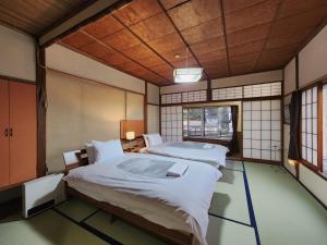 a large room with two beds and a window at Snow Monkey Lodge in Yamanouchi