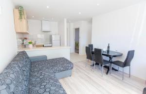 a living room with a couch and a table with chairs at Apartman Nick in Mlini