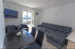 a living room with a table and a couch at Apartman Nick in Mlini