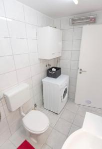 a white bathroom with a toilet and a sink at Apartman Nick in Mlini +28 photos