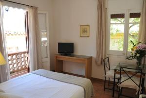 a bedroom with a bed and a desk with a television at Tibidabo Apartments in Barcelona