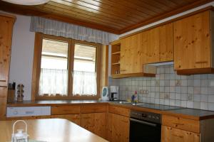 a kitchen with wooden cabinets and a counter top at Apartment Urstöger in Gosau +13 photos