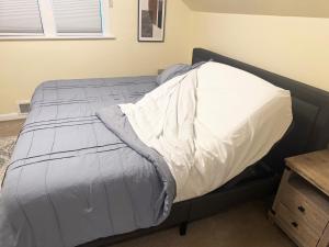 a bed with a white comforter in a bedroom at Cute as HECK! in Tacoma