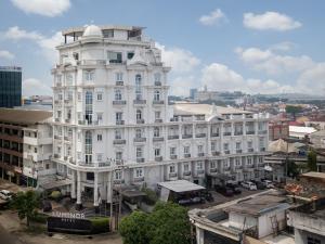 a large white building in the middle of a city at Luminor Hotel Palembang by WH Free Massage 10 Minutes in Palembang