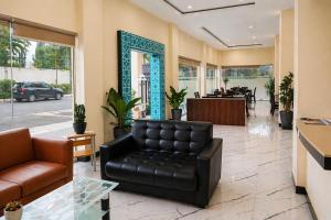 a lobby with a leather couch and a table at Hotel Grand Langkawi By ZIRI in Lheue