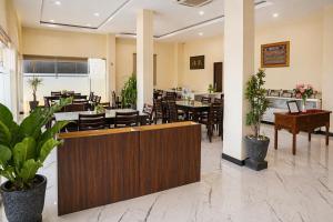 a restaurant with tables and chairs in a lobby at Hotel Grand Langkawi By ZIRI in Lheue