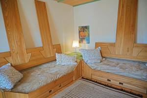 a room with two wooden beds with pillows at Kohlstatt Hof Ferienhaus in Verano