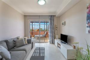 a living room with a couch and a television at Apartamento Duque Beach in Adeje