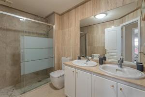 a bathroom with two sinks and a toilet and a shower at Apartamento Duque Beach in Adeje +18 photos