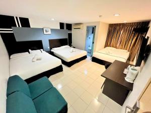 a hotel room with two beds and a blue couch at Seeds Hotel Klang Meru in Klang +20 photos