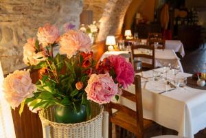 a vase of flowers on a table in a restaurant at Hotel La Planquette in Réquista