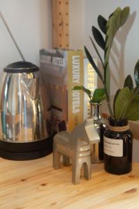 a wooden figurine of a horse sitting on a table with a plant at Uncle NID Hostel in Lat Krabang