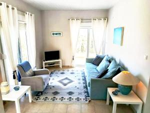 a living room with a blue couch and chairs at Bougainvillea Retreat above Faliraki in Kalithies