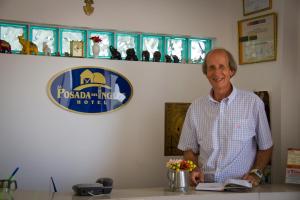 a man standing at a counter in a room at Hotel La Posada Del Ingles in Chiclayo