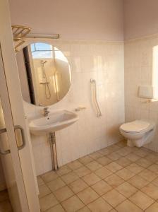 a bathroom with a sink and a toilet and a mirror at Hotel La Planquette in Réquista