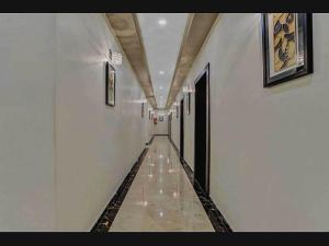 a hallway with a long corridor with white walls at Hotel O Raas Near Peera garhi Metro Station in New Delhi