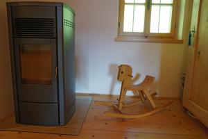 a wooden chair sitting next to a television in a room at Kohlstatt Hof Ferienhaus in Verano