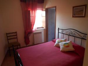 a bedroom with a bed with red sheets and a window at Casa de Hóspedes Celeste by Portugalferias in Odeceixe