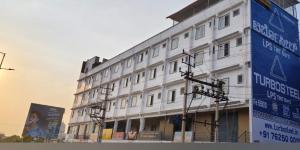 a white building with signs on the side of it at Sai Grands Stay In in Bangalore