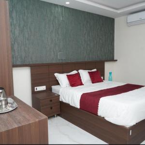 a bedroom with a large bed with red pillows at Sai Grands Stay In in Bangalore