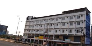 a white building on the side of a street at Sai Grands Stay In in Bangalore