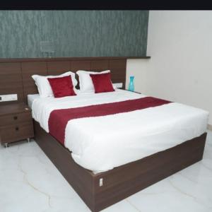 a bedroom with a large bed with red and white pillows at Sai Grands Stay In in Bangalore