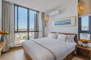 a bedroom with a large white bed with large windows at 鹿野山房 DeerHoliday Inn in Dali