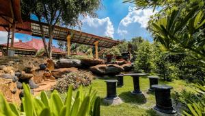 a garden with a table and some rocks at Griya Yodesiya Resort Semarang in Karangjati