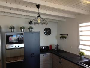 a kitchen with a refrigerator and a clock on the wall at Villa Vue Océan in Le Moule