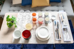 a table with plates and cups and utensils on it at Nagano Station Inn East in Nagano
