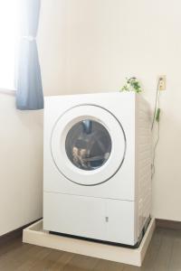 a washing machine on a stand in a room at Nagano Station Inn East in Nagano