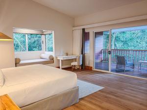 a bedroom with a bed and a balcony with a table and chairs at Cloud Forest Lodge in Monteverde Costa Rica
