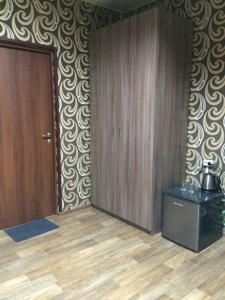 イヴァノヴォにあるAriel гостиницаのクローゼットとドア、床が備わる客室です。